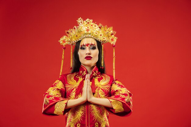 Chinese traditional graceful woman at studio over red wall