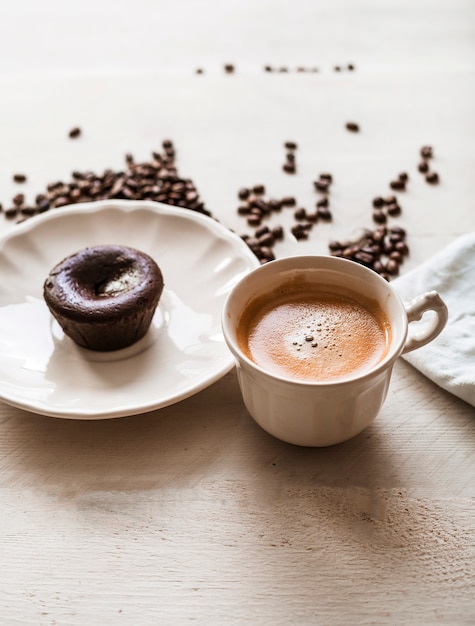 Choco lava cake on plate with coffee cup and roasted coffee beans