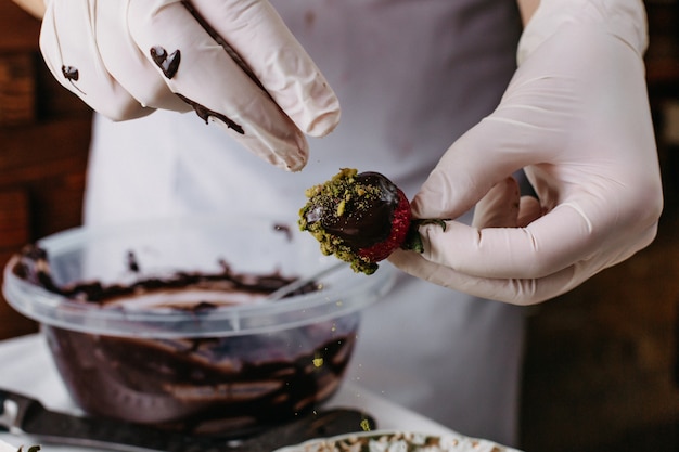 Free photo choco strawberry cook dunking red strawberry inside chocolate