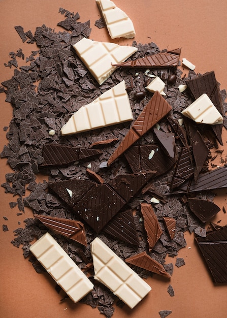 Free photo chocolate bar pieces on brown backdrop