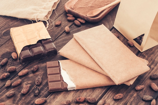 Free photo chocolate bars and cocoa beans on wooden table