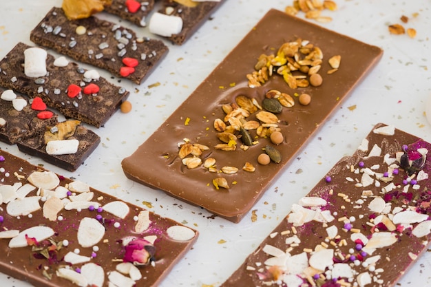 Chocolate bars with toppings on white background