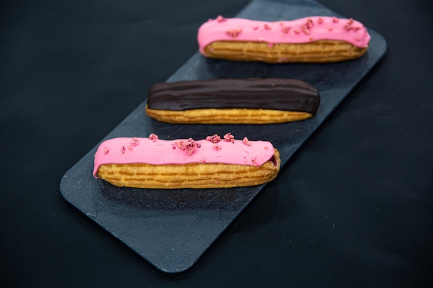 Free Photo chocolate and berry eclairs closeup on a black background