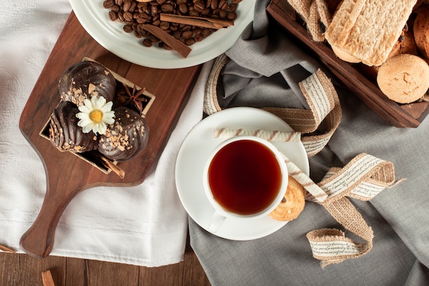 Chocolate biscuits tray and a cup of tea. Top view