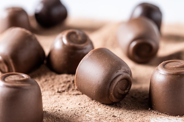 Chocolate bonbons and cocoa powder isolated on white background