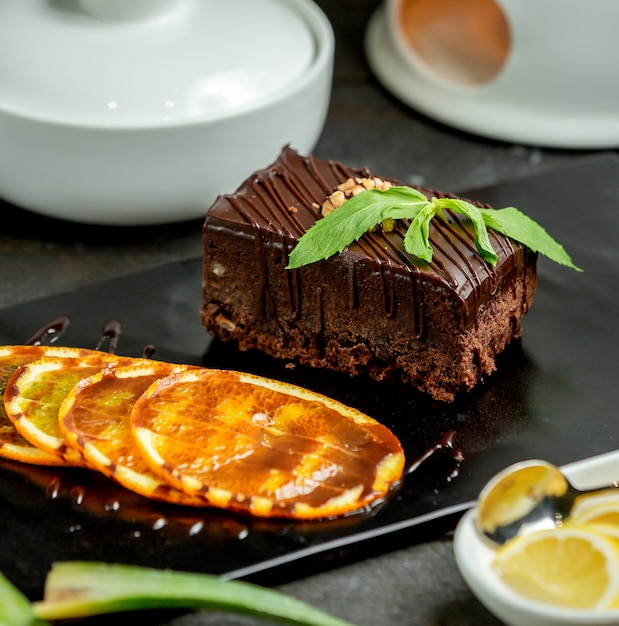 Free photo chocolate brownie portion served with orange slice