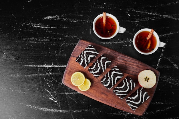 Chocolate brownies with cups of tea.