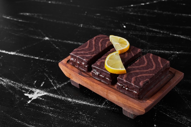 Free photo chocolate brownies on a wooden platter with lemon .