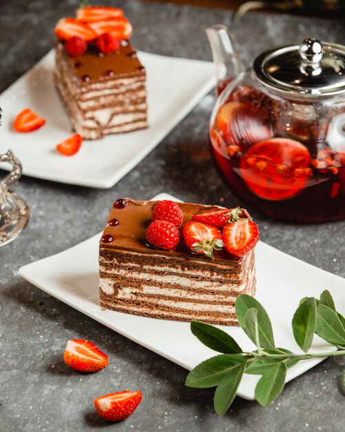 Chocolate cake with white cream sprinkled with cocoa and berries