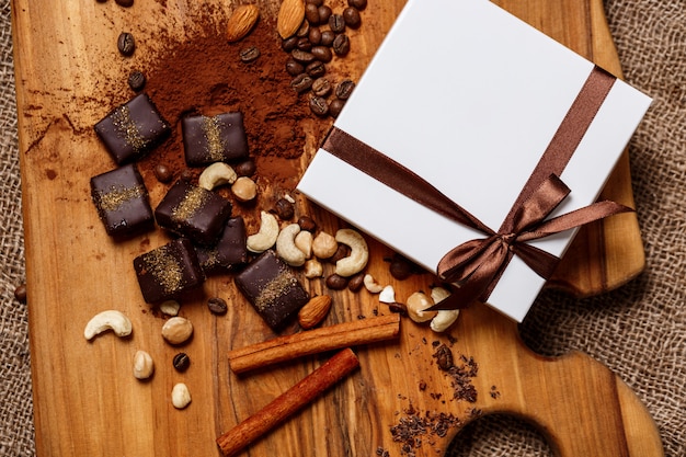 Free photo chocolate candies cinnamon and nuts on wood desk.