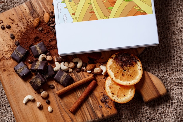 Free photo chocolate candies cinnamon orange and nuts on wood desk.