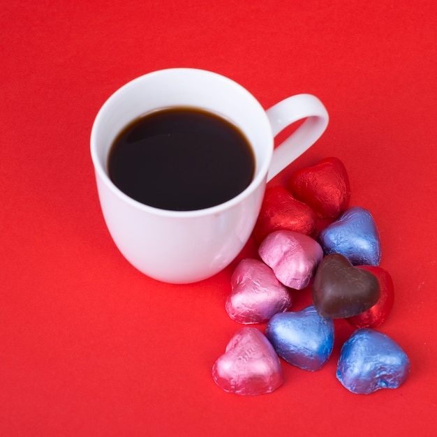 Free photo chocolate candies in heart shape with coffee cup