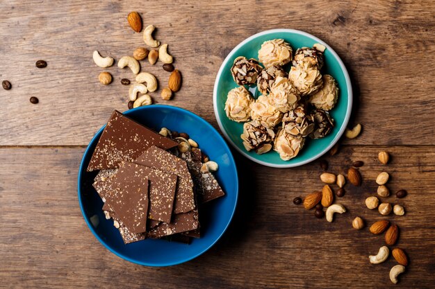 Chocolate candies and nuts on wood