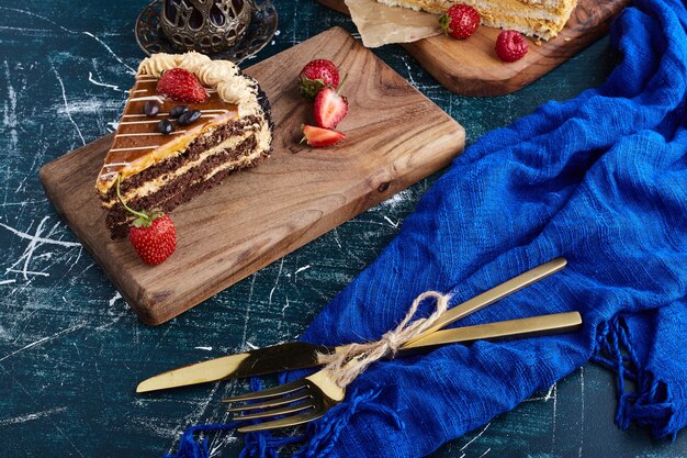 Chocolate caramel cake slices on a wooden board. 