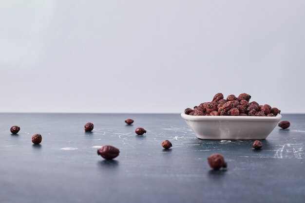 Chocolate coffee beans in a white ceramic plate.