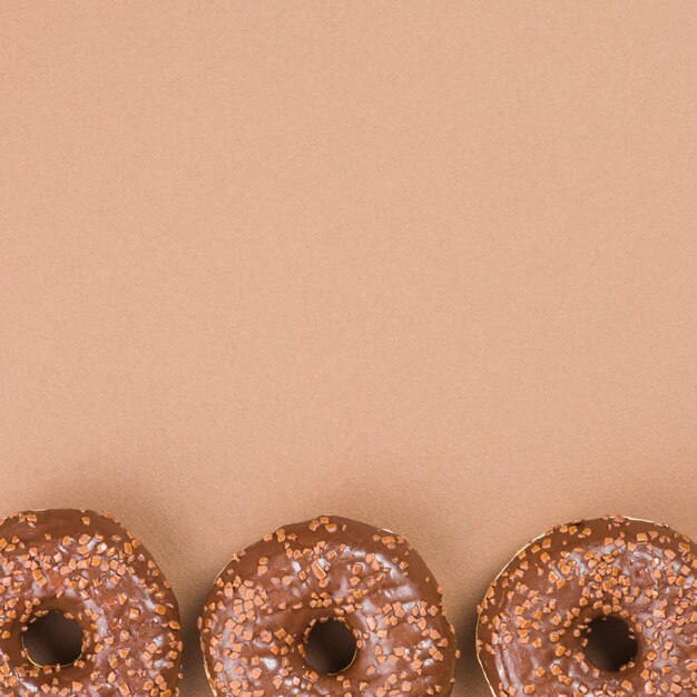 Chocolate donuts on brown background