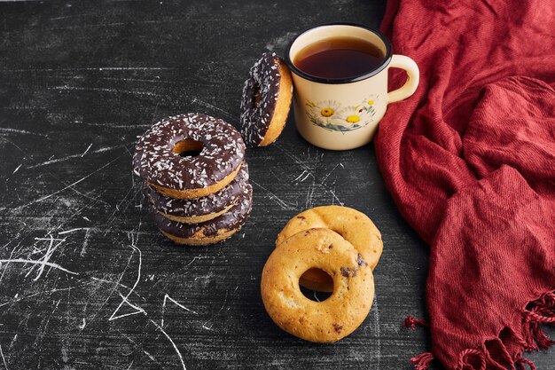 Chocolate doughnuts and cookies with a cup of tea. 