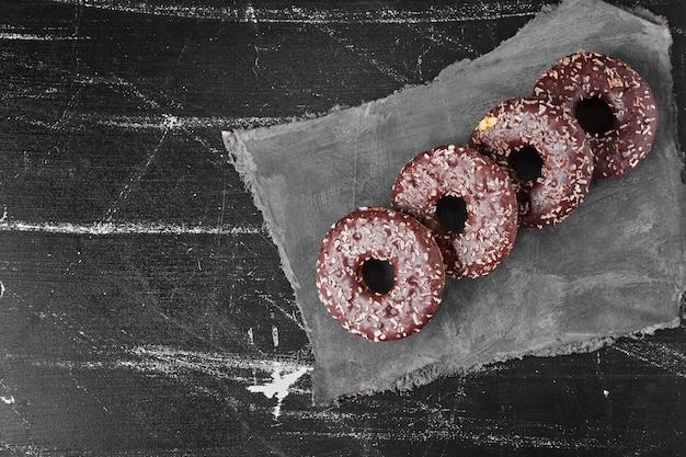 Free Photo chocolate doughnuts on a stone platter . high quality photo