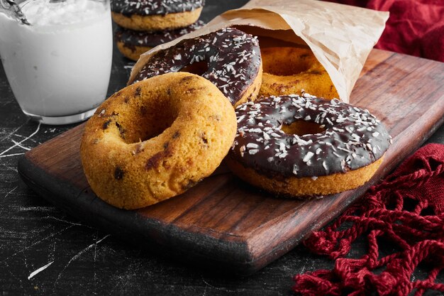 Chocolate doughnuts on a wooden board with curd. 