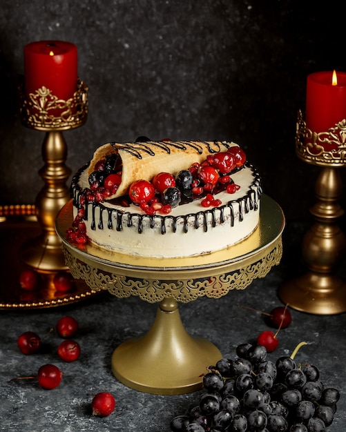 Chocolate dripping cake garnished with wrapped waffle with berries