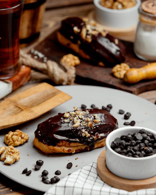 Chocolate eclair coated with chocolate and grated nuts