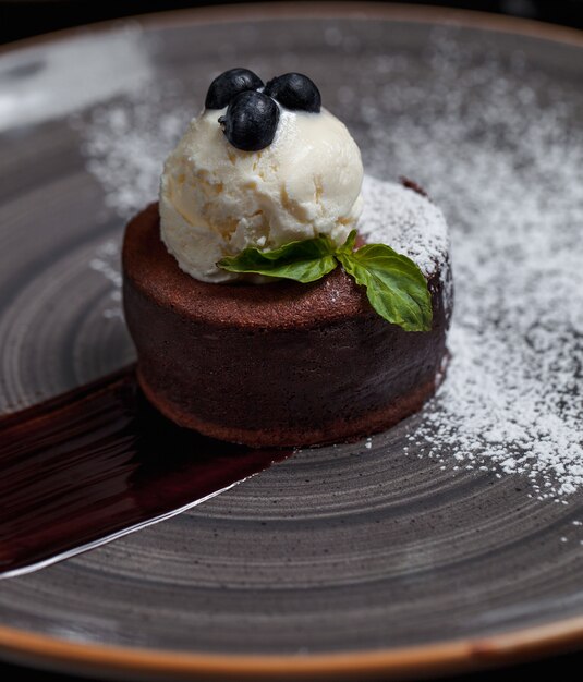 A chocolate fondue with ice cream ball and forest berries on the top