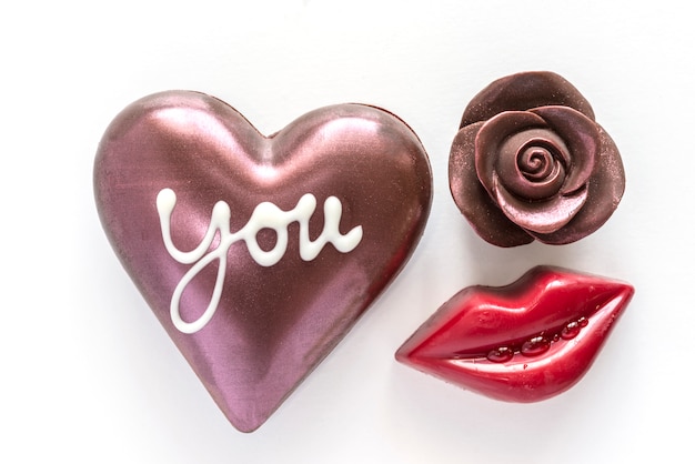 Free photo chocolate heart and chocolate rose with red mouth