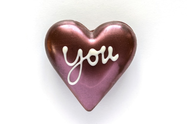 Chocolate heart shaped with word you on white background