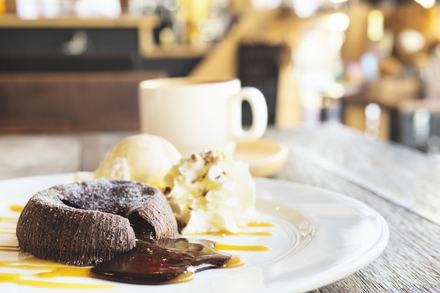 Chocolate lava cake in white plate with coffee cup in coffee shop