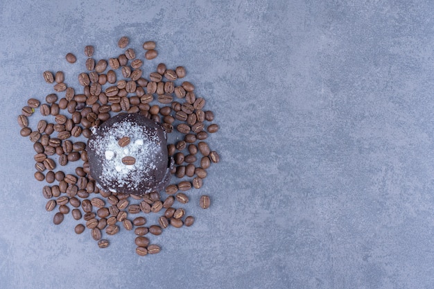 A chocolate muffin with coffee beans and sugar powder