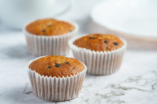 Chocolate muffins put on white marble floor