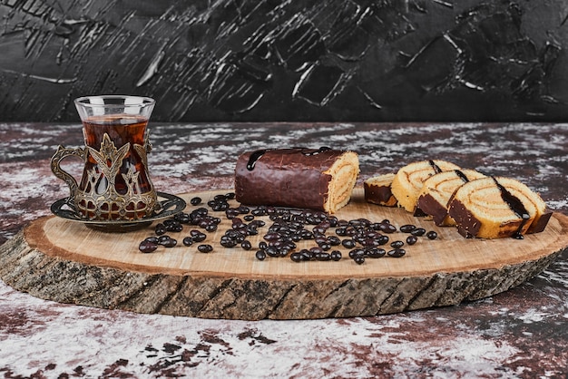 Free Photo chocolate rollcake with drink on a wooden board.