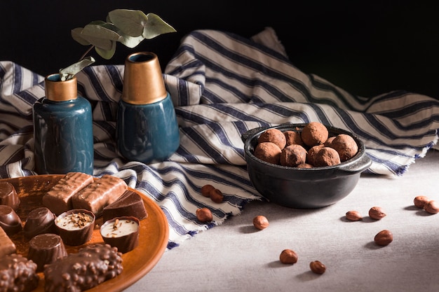 Chocolate sweets on plate and chocolate truffles in bowl