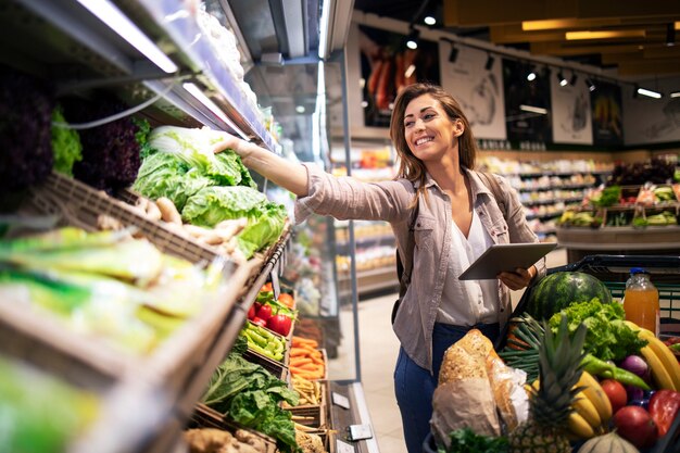 Choosing best vegetables on the shelf in grocery store