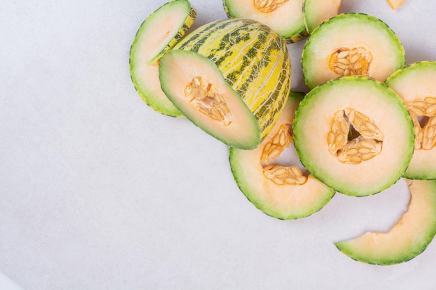 Chopped green melon on white table.