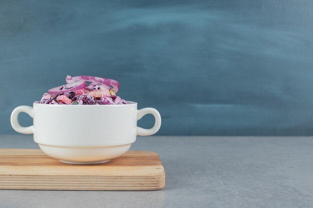 Chopped purple onion and cabbage salad in ceramic cups.