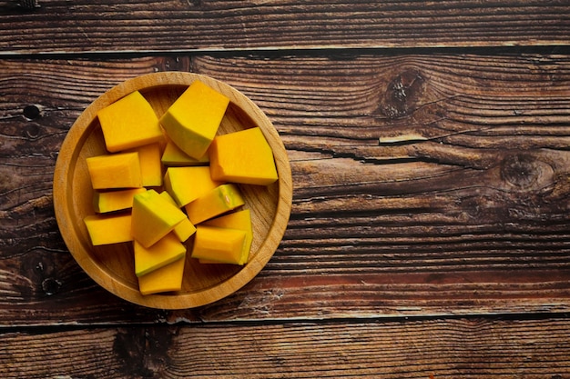 Free photo chopped raw pumpkin put on wooden bowl