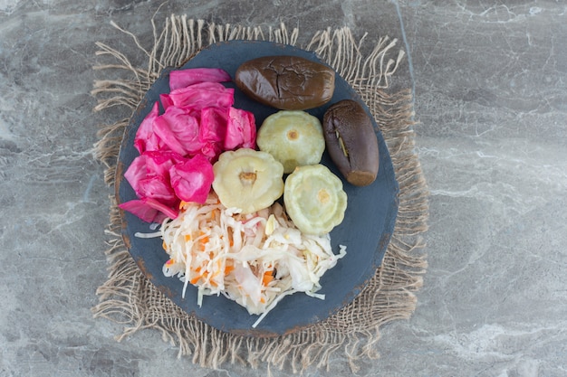 Free photo chopped vegetable pickle on wooden board over grey table.