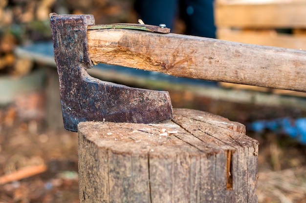 Free Photo chopping wood with ax. ax stuck in a log of wood