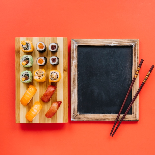 Chopsticks on blackboard near sushi