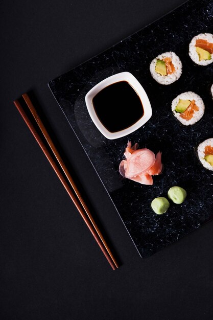 Chopsticks near crop plate with sushi 