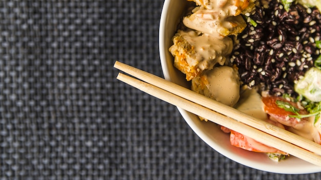 Free photo chopsticks on rice bowl with copy-space