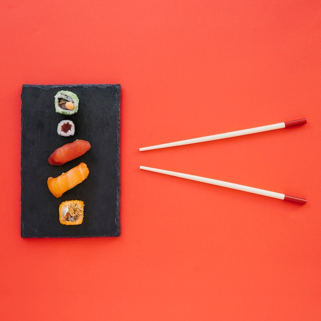 Free Photo chopsticks and sushi on red