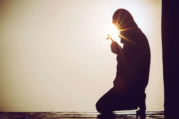 Free Photo christian people praying to jesus christ with dramatic sky background 