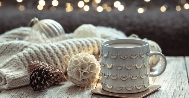 Christmas background with a beautiful cup and decor details on a blurred background with bokeh.