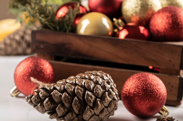 Christmas balls and cones in the wooden box and on the table.