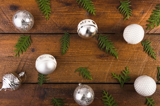 Free photo christmas balls and coniferous twigs on wood board