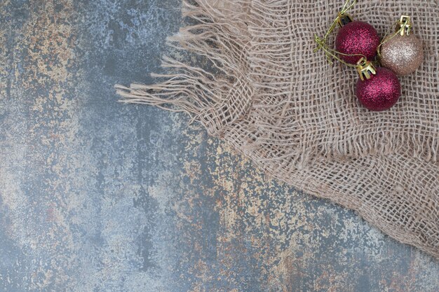 Christmas balls on marble table with burlap. High quality photo