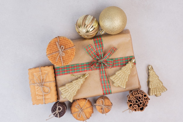 Free photo christmas box with cookies, waffles and cinnamon sticks in rope