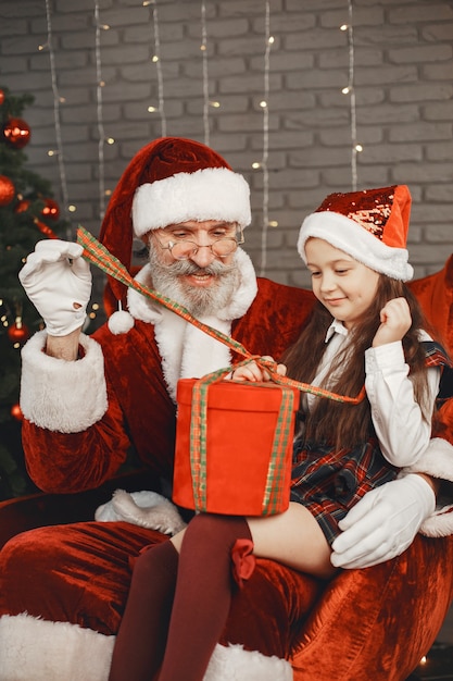 Free photo christmas, child and gifts. santa claus brought gifts to kid. joyful little girl hugging santa.